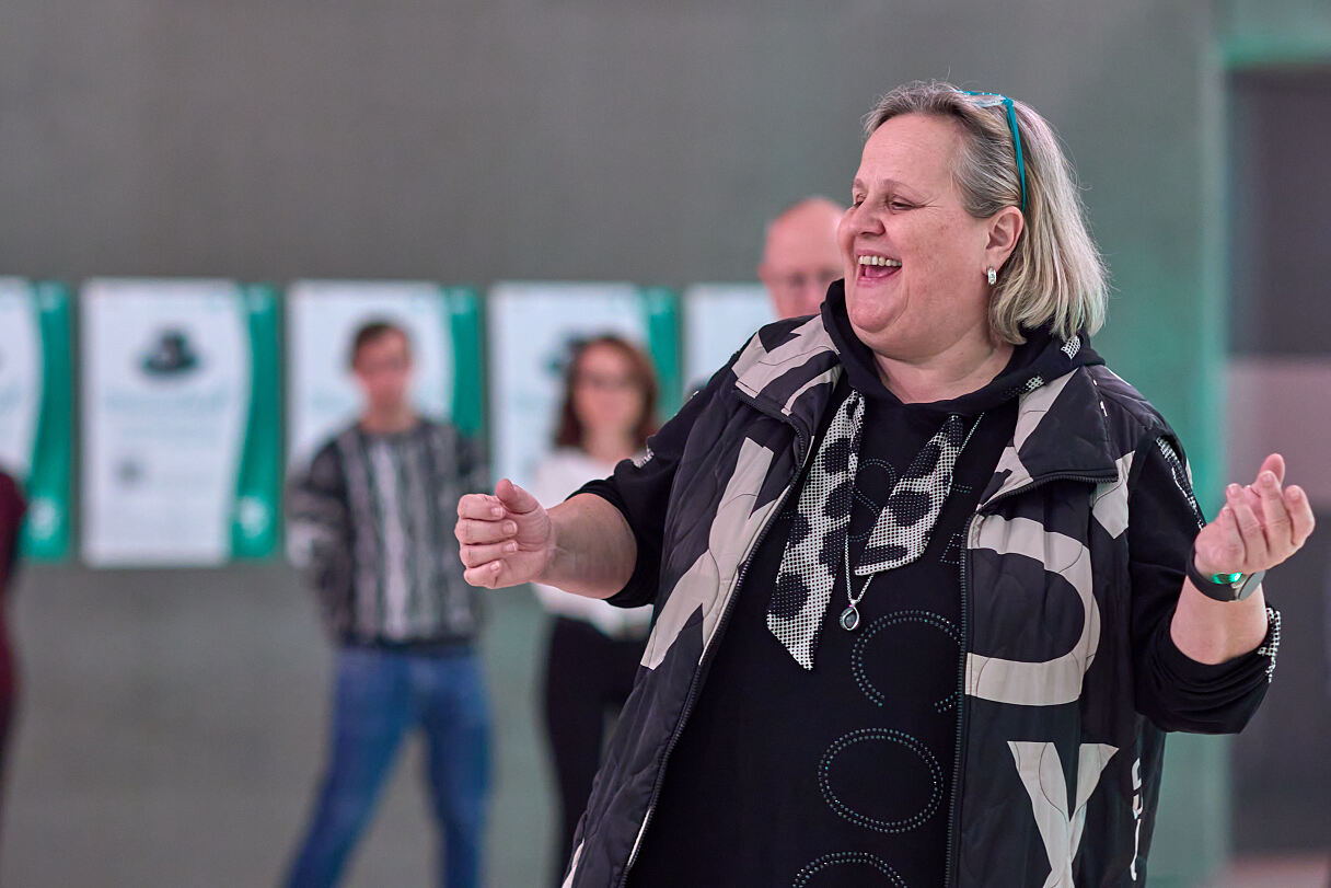 Tanzlehrerin Claudia Eichler stimmt die Besucherinnen und Besucher auf den Steirerball ein.